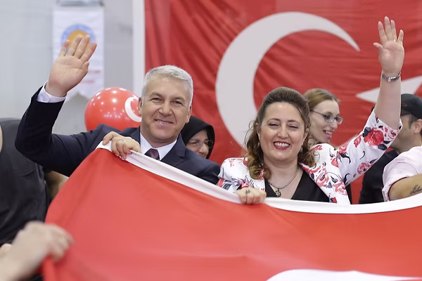 Yıldızkoru Koleji kurucuları, bir okul kutlamasında Türk bayrağıyla gülümserken